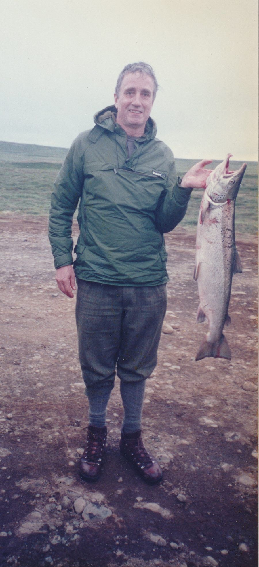 Master Colin Mackay holding a salmon during a fishing trip in Scotland