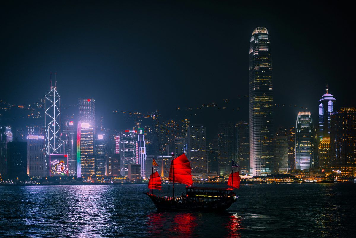 Hong Kong harbour at night with a traditional junk boat
